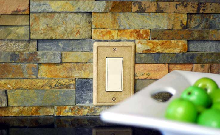 Ochre Ledgestone Panel Backsplash with Lightswitch next to a bowl of Apples