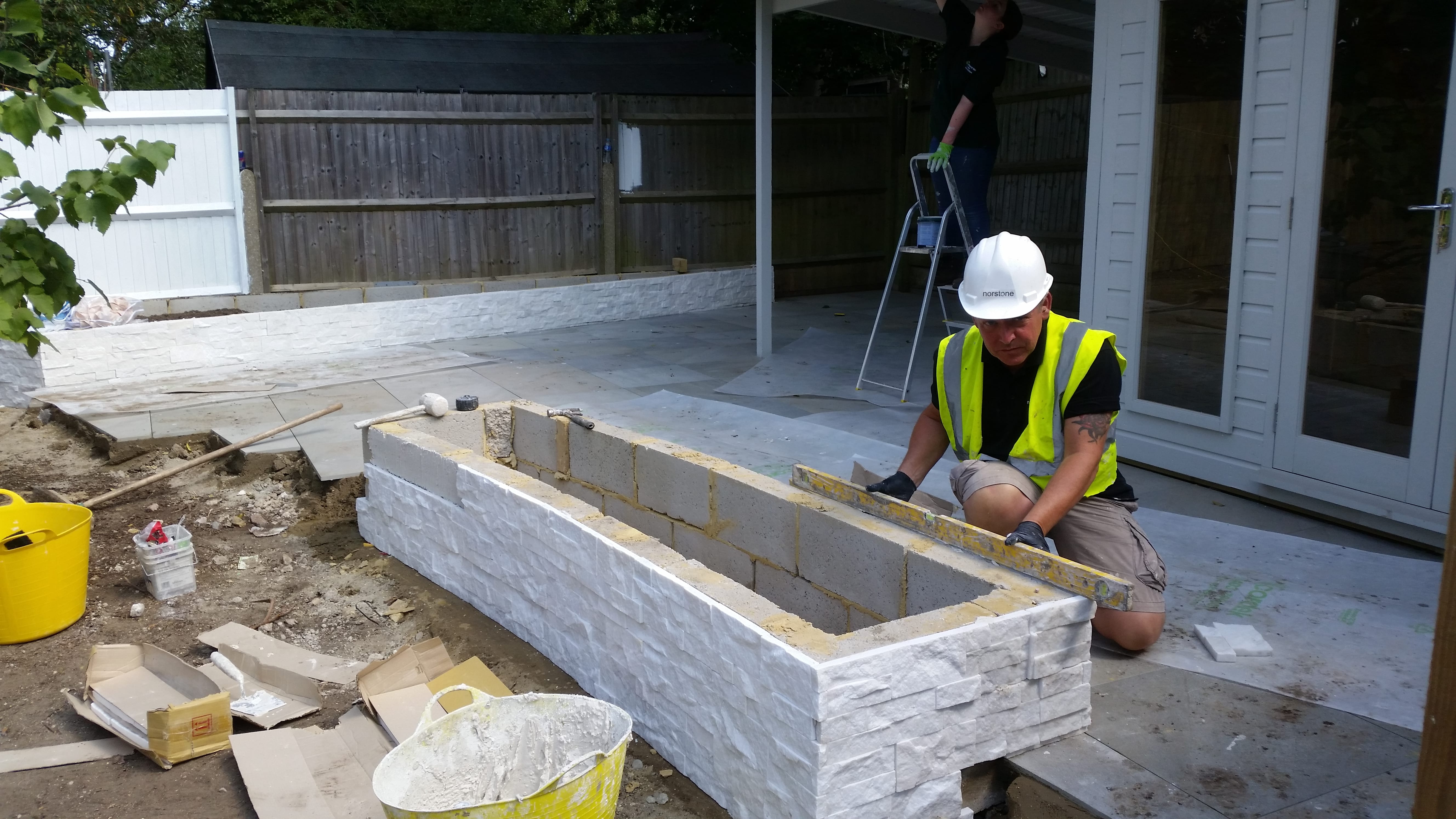 White Stacked Stone being installed on a curved planter box