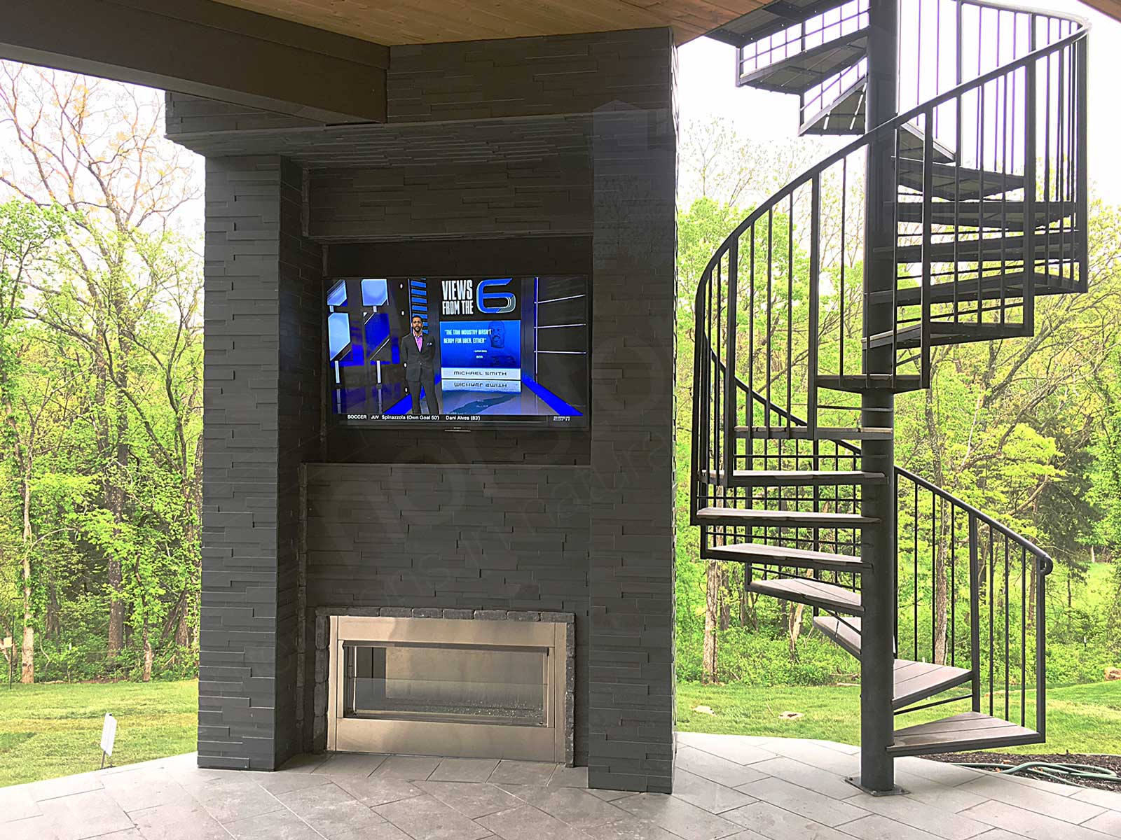 Outdoor fireplace and tv recessed into column clad in basalt 3d ledge stone