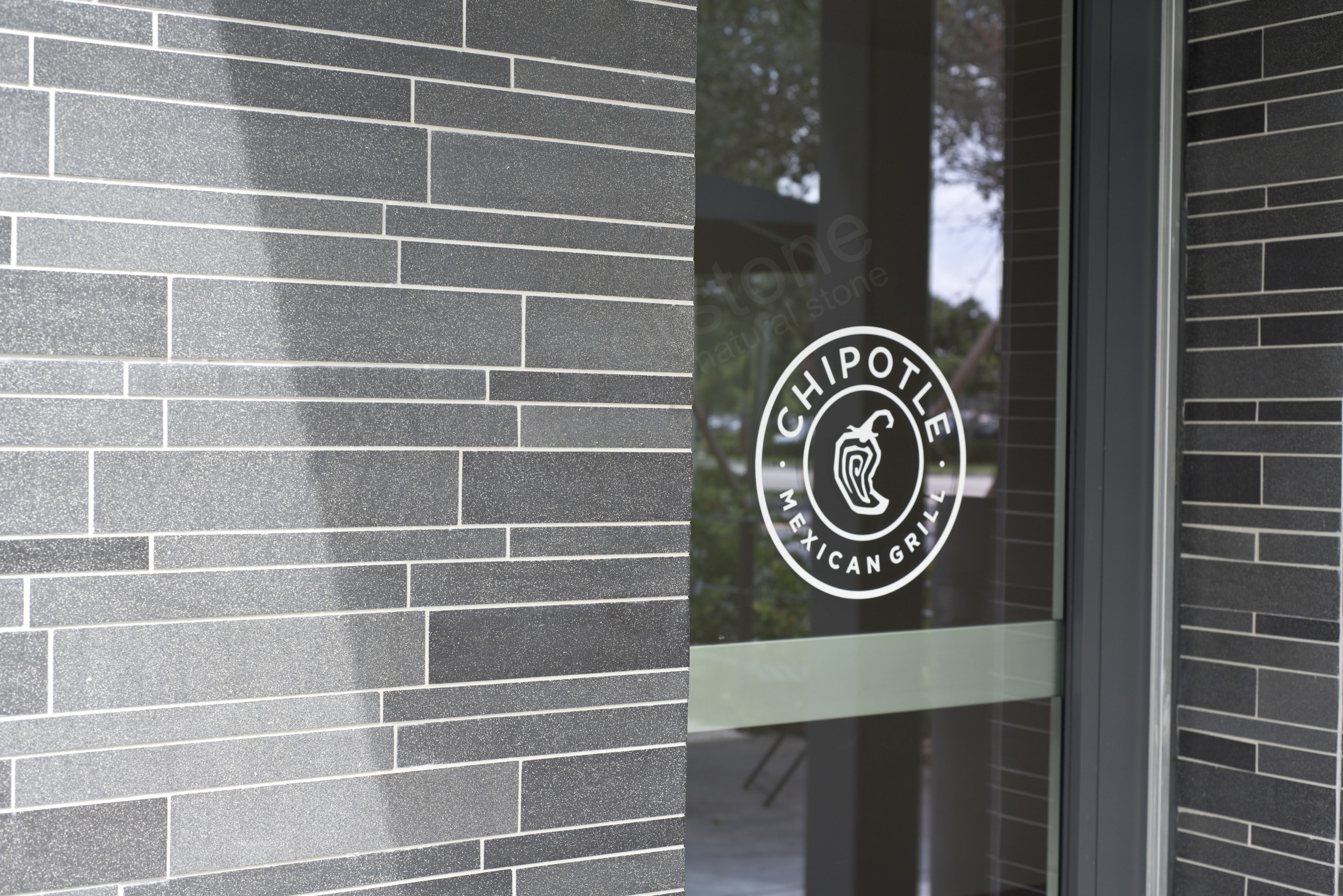 Basalt Mosaic Interlocking Tile with White Grout complementing Chipotle Logo