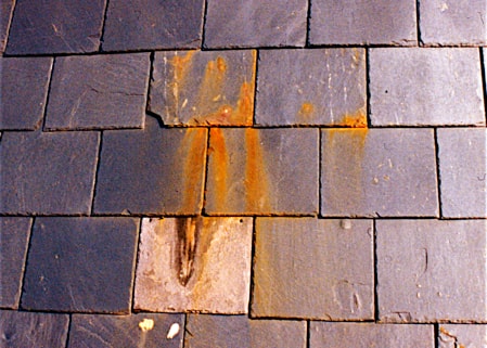 Slate roofing tiles that have not been sealed and are rusting due to high iron content