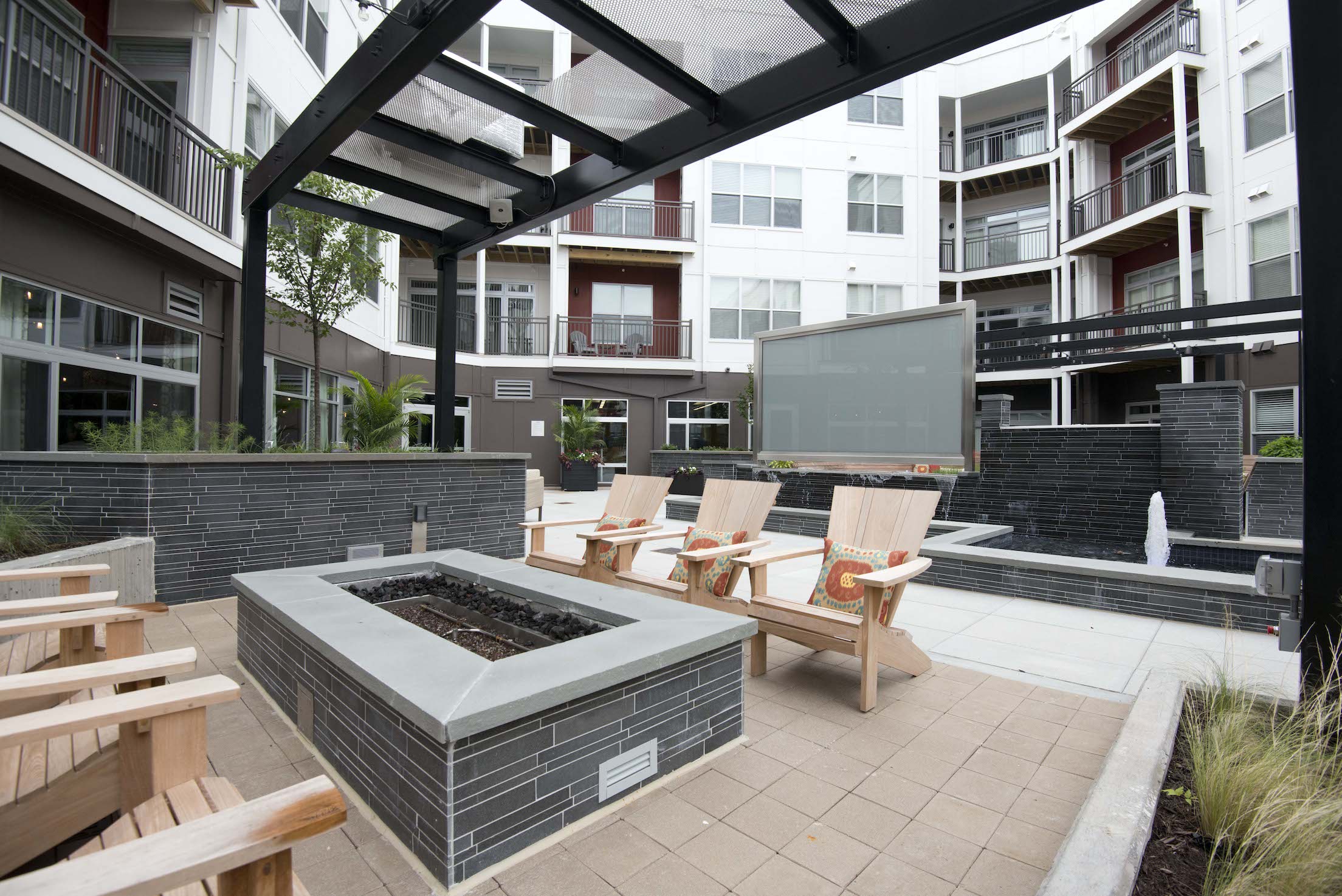 Apartment common area gas firepit with basalt stone tile used as the veneer