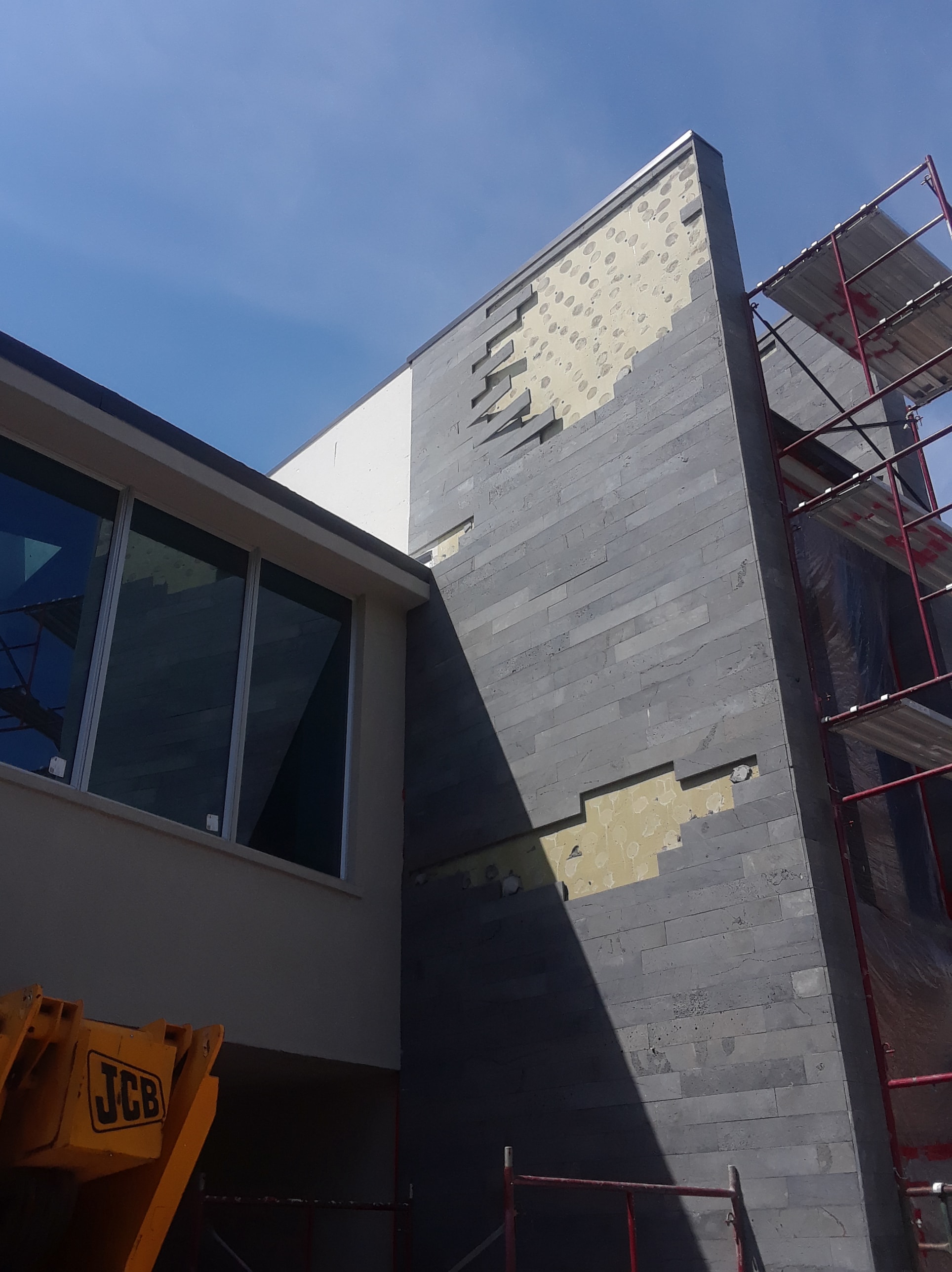 Stone Veneer Installation on an exterior feature wall failing due to a spot bonding installation technique