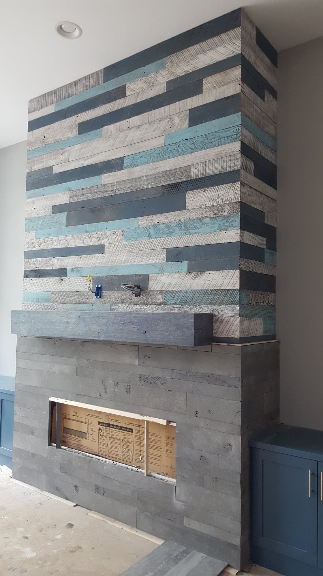 Norstone Platinum Planc Lavastone tiles in a mixed medium fireplace with barnwood strips above the mantle